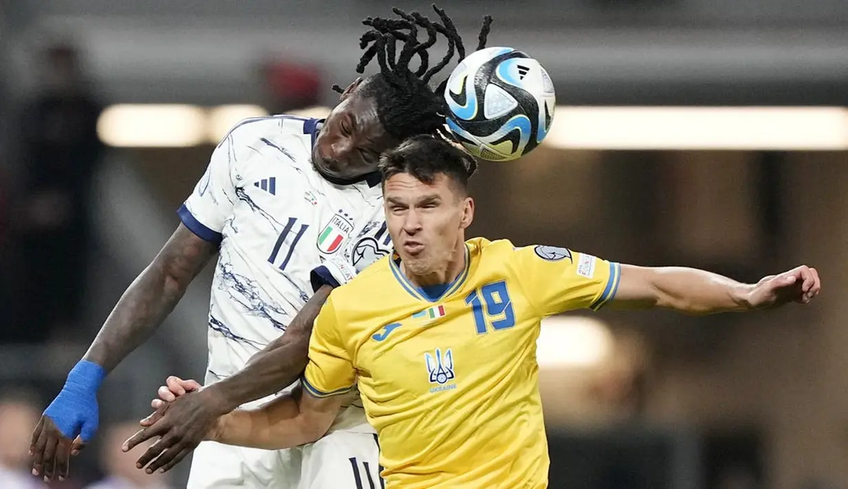 Pemain Italia, Moise Kean, duel udara dengan pemain Ukraina, Oleksandr Tymchyk, dalam duel matchday 10 Kualifikasi Euro 2024 Grup C di Stadion BayArena, Jerman, Selasa, (21/11/2023). (AP Photo/Martin Meissner)