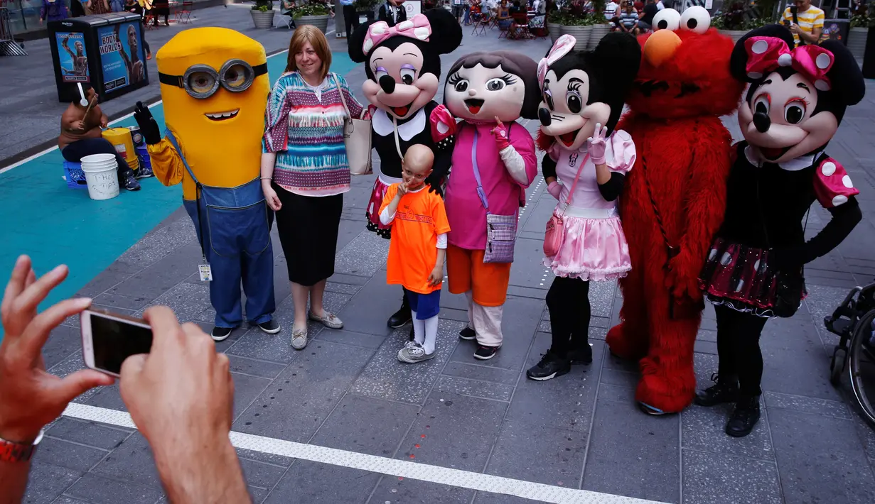 Seorang pengunjung berfoto bersama sejumlah karakter kartun di Times Square, New York, Selasa (21/6). Kehadiran karakter-karakter kartun tersebut mengundang warga untuk foto bersama. (REUTERS/Lucas Jackson)