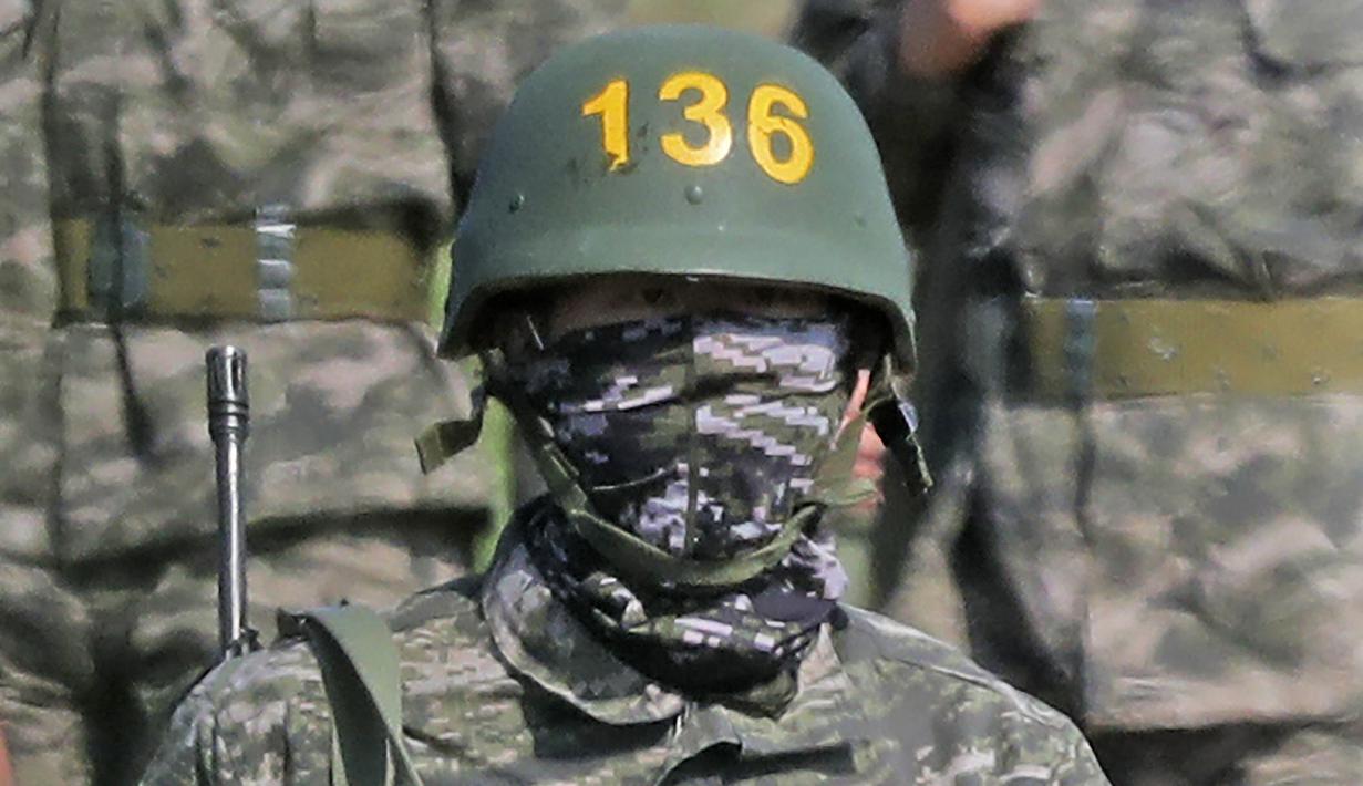 Pemain Tottenham Hotspur, Son Heung-min, berseragam militer lengkap dengan senjata saat mengikuti wajib militer di Korsel, (6/5/2020). Penundaan Premier League karena virus corona dimanfaatkan Son Heung-min untuk mengikuti program wajib militer. (AP/Park Ji-ho)