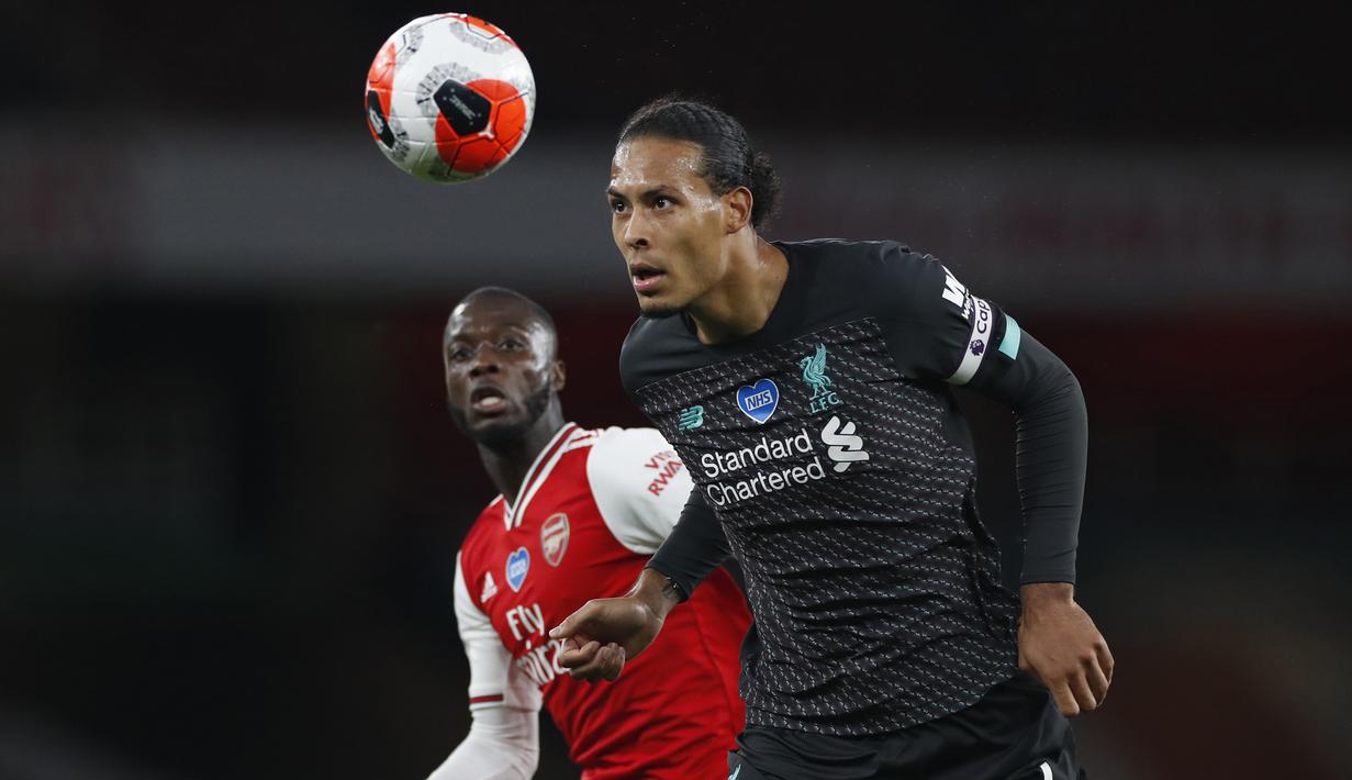 Bek Liverpool, Virgil van Dijk, berebut bola dengan gelandang Arsenal, Nicolas Pepe, pada laga lanjutan Premier League pekan ke-36 di Emirates Stadium, Kamis (16/7/2020) dini hari WIB. Arsenal menang 2-1 atas Liverpool. (AFP/Paul Childs/pool)