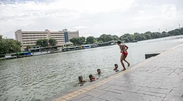 Sejumlah anak berenang di Danau Sunter, Jakarta, Selasa (2/2/2021). Minimnya lahan bermain anak membuat mereka memanfaatkan tempat yang tidak semestinya untuk bermain karena adanya risiko hanyut dan tenggelam bila tidak mampu untuk berenang. (Liputan6.com/Faizal Fanani)