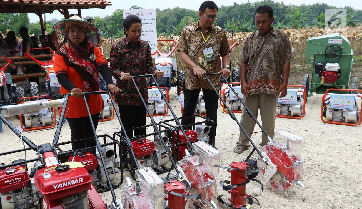 Menteri BUMN Rini Soemarno (dua kiri) meninjau perlengkapan pendukung produksi pertanian di Tuban, Jawa Timur, Jumat (9/3). Dalam kesempatan ini pemerintah menyalurkan KUR, Kartu Tani, dan CSR BNI. (Liputan6.com/Angga Yuniar)