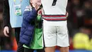 Penyerang Portugal Cristiano Ronaldo memberikan jerseynya untuk fans cilik Irlandia pada akhir laga Grup A Kualifikasi Piala Dunia 2022 Zona Eropa di Stadion Aviva, Jumat (12/11/2021) dinihari WIB. Ronaldo yang tengah berjalan menuju ruang ganti tiba-tiba didatangi fans cilik. (AP/Peter Morrison)