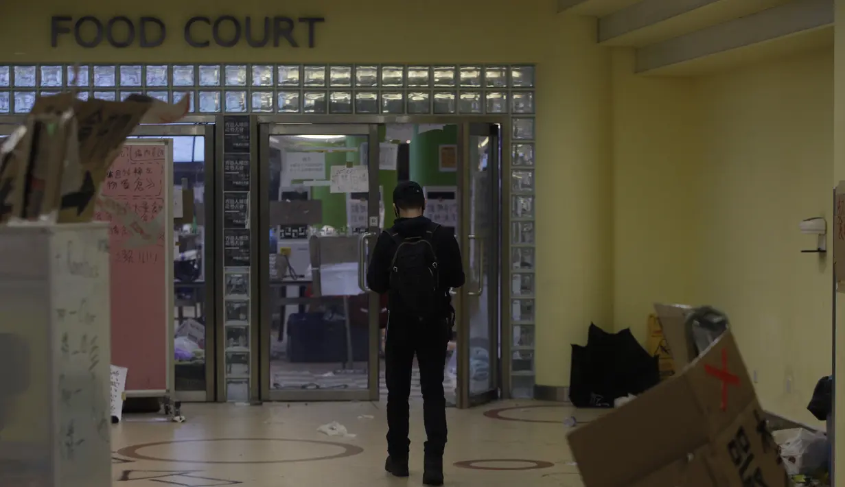 Seorang pengunjuk rasa berjalan di dalam kampus Universitas Politeknik Hong Kong di Hong Kong (22/11/2019). Sebagian besar pengunjuk rasa yang mengambil alih universitas minggu lalu telah pergi, tetapi jumlah yang tidak diketahui tetap di dalam selama berhari-hari. (AP Photo/Achmad Ibrahim)