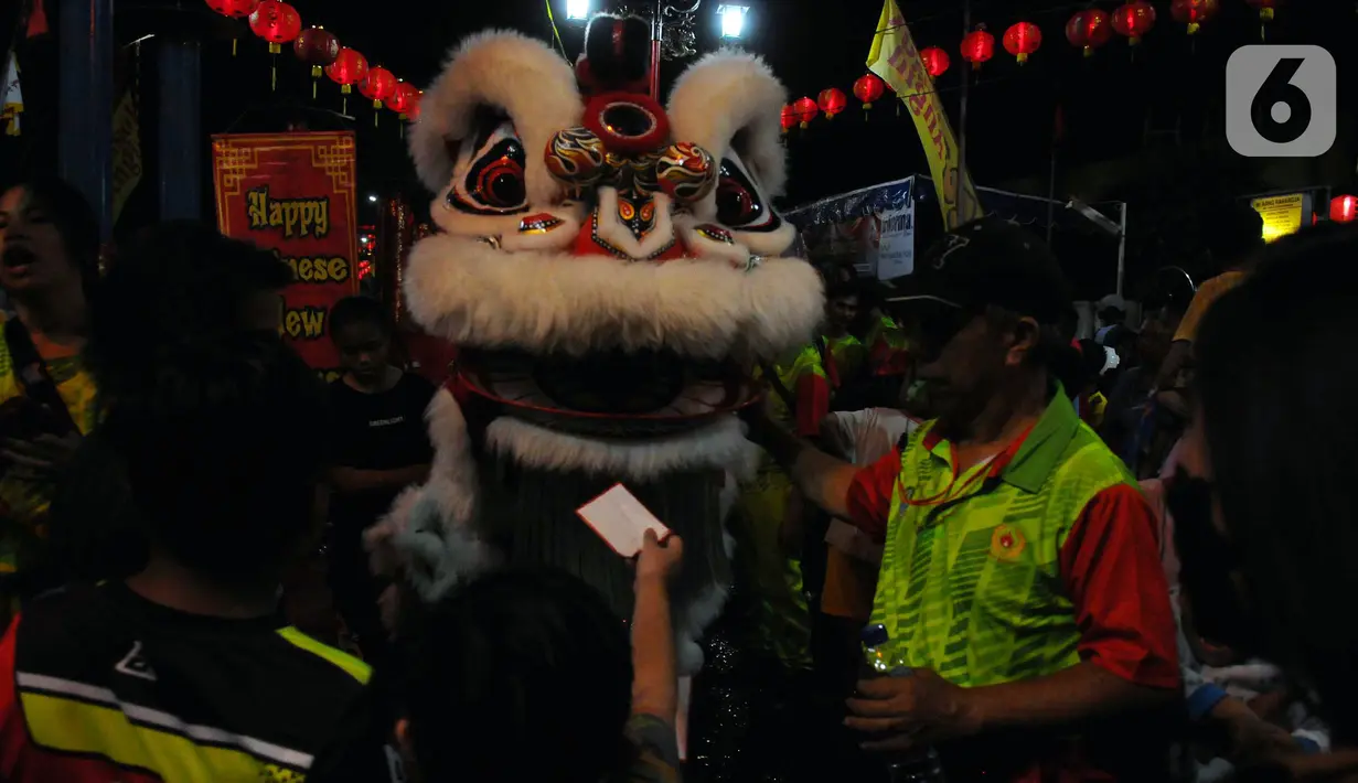 Warga keturunan Tionghoa memberi angpao saat atraksi barongsai jelang perayaan Cap Go Meh di Klenteng Hok Lay Kiong Bekasi, Jawa Barat, Sabtu (4/2/2023). Perayaan Cap Go Meh akan digelar dengan pawai atraksi barongsai, patung dewa, hingga naga-naga dengan rute pawai itu dari Jalan Mayor Oking-Lampu Merah Kartini-Juanda-Agus Salim-Jalan Perjuangan-Juanda dan kembali lagi ke Jalan Mayor Oking. (merdeka.com/Imam Buhori)