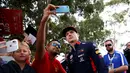 Pembalap F1 Red Bull, Max Verstappen berselfie bersama penggemarnya saat tiba di Sirkuit Melbourne Grand Prix di Melbourne, Jumat (15/3). (Reuters/Edgar Su)