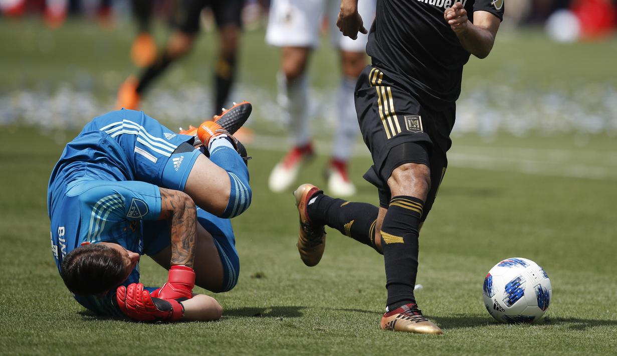 Kiper LA Galaxy, David Bingham (kiri) jatuh saat berebut bola dengan pemain Los Angeles FC,  Carlos Vela pada laga Major League Socccer di StubHub Center,  California, (31/3/2018). LA Galaxy menang 4-3. (AP/Jae C. Hong)