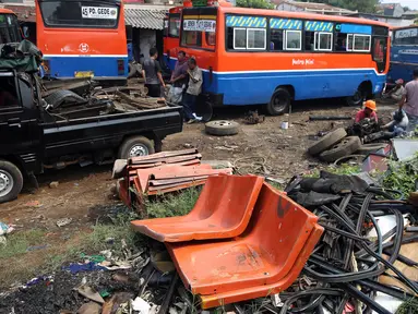 Pekerja memotong dan memisahkan sisa bagian rangka angkutan Metromini di salah satu pool Metromini, Jalan Pulogebang, Jakarta, Rabu (3/1). Satu unit bangkai metromini dihargai senilai Rp12 juta oleh pengepul besi bekas. (Liputan6.com/JohanTallo)