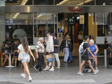 Orang-orang berjalan di luar pusat perbelanjaan Westfield di Bondi Junction di Sydney, Jumat (19/4/2024). Pusat perbelanjaan tersebut dibuka kembali untuk bisnis pada hari Jumat untuk pertama kalinya sejak menjadi lokasi penikaman massal yang menewaskan enam orang pada Sabtu, 13 April lalu. (AP Photo/Mark Baker)