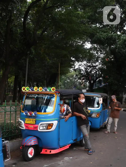 Pengemudi bajaj tengah menunggu penumpang di kawasan Taman Puring, Jakarta, Minggu (11/7/2021). Dampak dari PPKM darurat membuat penghasilan para pengemudi bajaj menurun drastis hingga 70 pesen. (Liputan6.com/Angga Yuniar)
