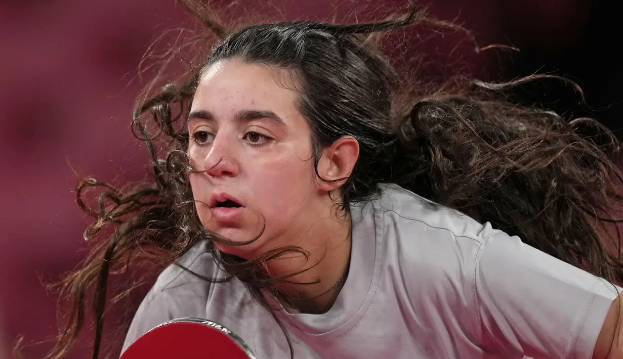 Petenis meja Suriah Hend Zaza saat melawan Liu Jia dari Austria selama pertandingan babak penyisihan tunggal tenis meja putri di Olimpiade 2020 di Tokyo, Sabtu (24/7/2021). Zaza adalah atlet tenis meja kedua sepanjang sejarah yang tampil membela Suriah di olimpiade. (AP Photo/Kin Cheung)