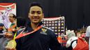 Ahmad Zigi Zaresta memamerkan medali yang diperoleh di nomor Junior Kata Male di WKF World Junior, Cadet and U-21 Championship 2015 di ICE Serpong, Banten, Kamis (12/11/2015). Zigi menyumbang emas pertama bagi Indonesia. (Liputan6.com/Helmi Fithriansyah)