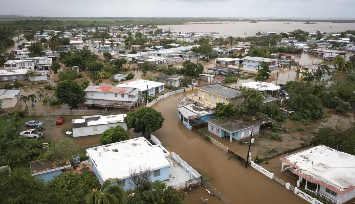 Playa Salinas digenangi air setelah Badai Fiona berlalu di Salinas, Puerto Rico, Senin, 19 September 2022. Menurut pihak berwenang, tiga orang berada di dalam rumah dan dilaporkan telah diselamatkan. (AP Photo/Alejandro Granadillo)