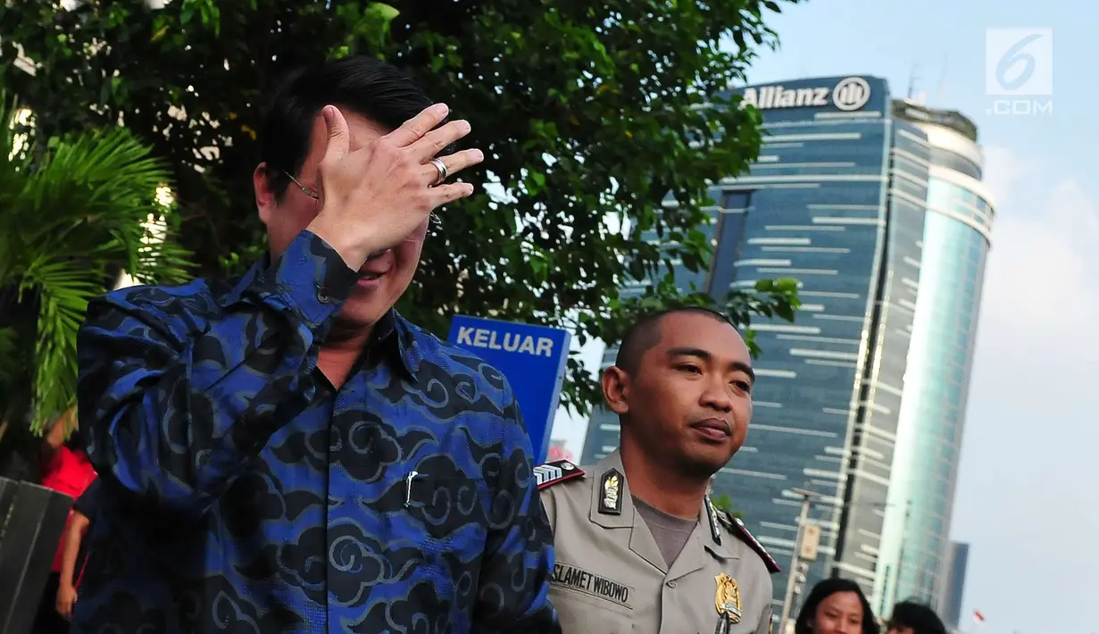 Dedi Prijono menutupi wajahnya saat dimintai keterangan awak media usai menjalani pemeriksaan di gedung KPK, Jakarta (1/8). Dedi Prijono dimintai keterangan untuk melengkapi berkas Ketua DPR Setya Novanto. (LIputan6.com/Helmi Afandi)