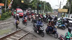 Kendaraan menyeberangi perlintasan kereta api di Lenteng Agung, Jakarta, Selasa (13/3). Untuk mengurai kemacetan imbas antrian kendaraan berputar balik di pintu kereta IISIP, Pemprov DKI berencana membangun flyover U-Turn. (Liputan6.com/Immanuel Antonius)