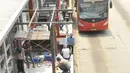 Suasana perbaikan halte Busway Harmoni, Jakarta, Jum'at (29/1/2016). Perbaikan dilakukan pada jalur masuk penumpang karena sempat ambruk beberapa waktu lalu. (Liputan6.com/Faisal R Syam)