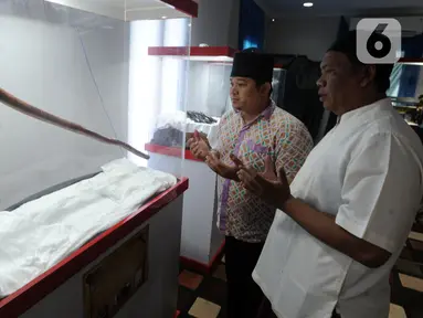 Pengunjung menyaksikan tongkat peninggalan Nabi Muhammad SAW dalam pameran artefak asli Rasulullah di Masjid Jami At-Taqwa, Sukamaju, Depok, Jawa Barat, Selasa (29/12/2020). Empat peninggalan Nabi Muhammad SAW dipamerkan hingga esok hari. (merdeka.com/Arie Basuki)