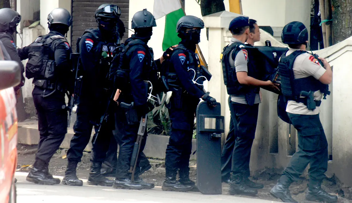 Polisi bersenjata api lengkap mengepung kantor Kelurahan Arjuna, Kecamatan Cicendo, Bandung, Senin (27/2). Terduga teroris yang membawa senjata api menembakkan senjatanya ke luar, di mana polisi tengah mengepung bangunan kelurahan. (Timor Matahari/AFP)