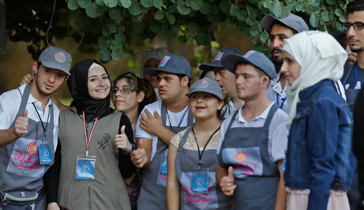 Sejumlah anak down syndrome Abdel Rahman foto bersama selama festival "Sham gather us" di Damascus (11/7). Enam belas anak laki-laki dan perempuan down syndrome bekerja di Cafe Sucet melayani pelanggan. (AFP Photo/Louai Beshara)