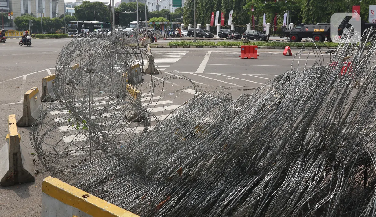 Pihak kepolisian menutup akses jalan di kawasan Harmoni, Jakarta, Sabtu (24/7/2021). Kepolisian menyiapkan kawat berduri di kawasan Harmoni untuk mengantisipasi aksi demonstrasi dengan tuntutan menolak perpanjangan pemberlakuan pembatasan kegiatan masyarakat (PPKM). (Liputan6.com/Herman Zakharia)