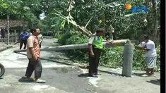 Relawan dibantu warga, TNI dan POLRI bergotong royong menyingkirkan potongan tiang listrik yang patah akibat diterjang angin kencang.