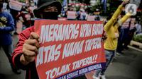 Massa yang tergabung dalam Front Perjuangan Rakyat (FPR) membawa poster saat berunjuk rasa di Jalan Gerbang Pemuda, Senayan, Jakarta, Jumat (14/8/2020). Dalam aksinya mereka menolak rencana pengesahan RUU Cipta Kerja atau omnibus law. (Liputan6.com/Faizal Fanani)