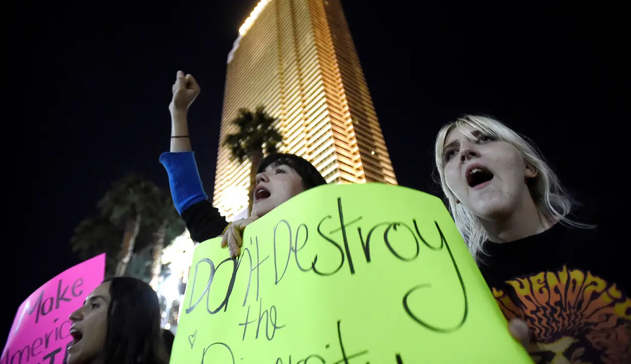 Pengunjuk rasa membawa poster saat memprotes kemenangan Trump dalam pemilihan Presiden AS, di dekat Trump International Hotel & Tower di Las Vegas, Rabu (9/11). Mereka meneriakkan yel-yel bahwa Donald Trump "bukan presiden kami." (REUTERS/David Becker)