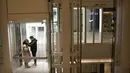 Pasangan memakai masker  naik lift di pusat perbelanjaan yang sepi pengunjung di Beijing (28/1/2020).  Mewabahnya virus corona membuat pusat perbelanjaan di Beijing, China, sepi pengunjung. (AP Photo/Mark Schiefelbein)