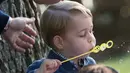 Pangeran George saat bermain pistol gelembung sabun dalam sebuah pesta untuk anak-anak di Government House di Victoria, British Columbia, Kanada, (29/9). (REUTERS/Chris Wattie)