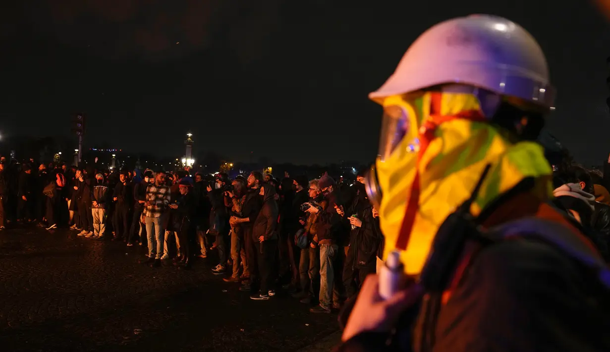 "Macron, Mundur!" teriak beberapa demonstran saat berbaris ke barisan polisi antihuru-hara. (AP Photo/Lewis Joly)