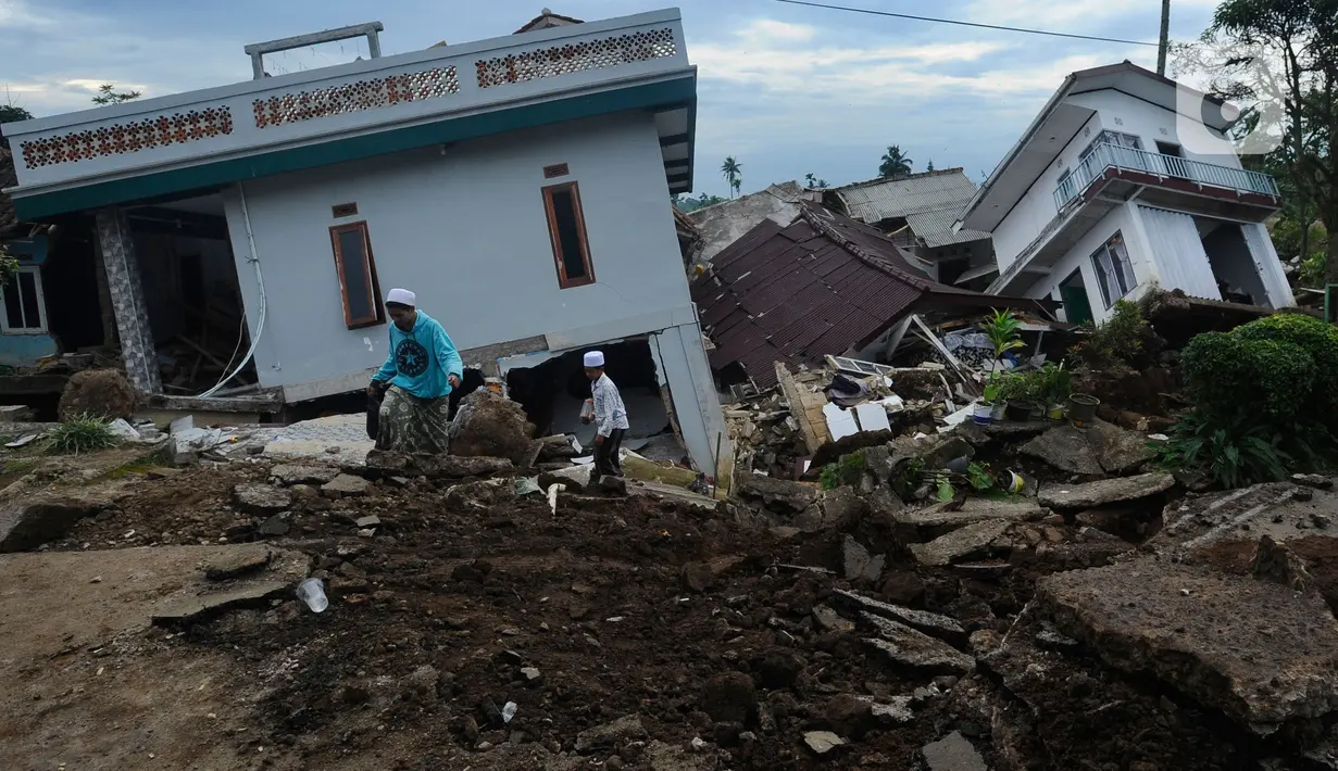 Santri berjalan di antara puing banguan yang hancur akibat gempa di Pesantren Al Burok, Kampung Cisarua, Desa Sarampad, Cianjur, Jawa Barat, Rabu (21/11/2022). Gempa bumi dengan magnitude 5,6 di Cianjur Jawa Barat yang berpusat di darat 10 km barat daya embuat sejumlah rumah dan bangunan rusak. (merdeka.com/Arie Basuki)