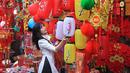 Seorang wanita melihat lentera di pasar tradisional Tahun Baru Imlek "Tet" di kawasan tua Hanoi, Vietnam, Jumat (28/1/2022). Vietnam merayakan Tahun Baru Imlek yang akan datang di tengah peringatan terhadap perjalanan dan pertemuan besar karena COVID -19. (AP Photo/Hau Dinh)