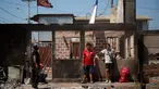 Warga beristirahat di dekat sebuah rumah yang terbakar setelah kebakaran hutan di Poblacion Pompeya Sur, Quilpue, Chili pada tanggal 6 Februari 2024. (Javier TORRES/AFP)