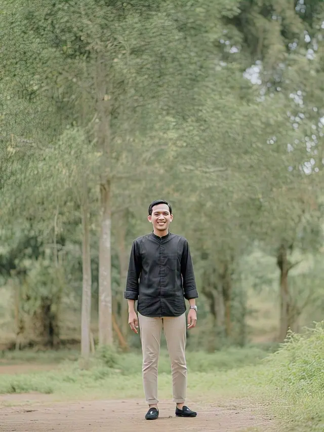 Model pria memakai kemeja hitam dengan celana chino beige/Meta AI