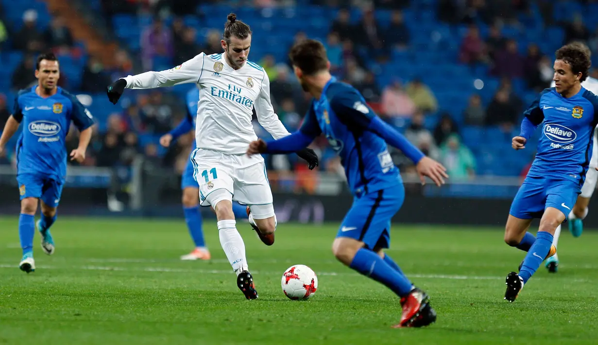 Pemain Real Madrid, Gareth Bale menggiring bola dengan kawalan pemain Fuenlabrada pada laga Copa del Rey 2017-2018 di Stadion Santiago Bernabeu, Selasa (28/11). Madrid lolos ke 16 besar Copa del Rey, meski imbang 2-2. (AP Photo/Francisco Seco)