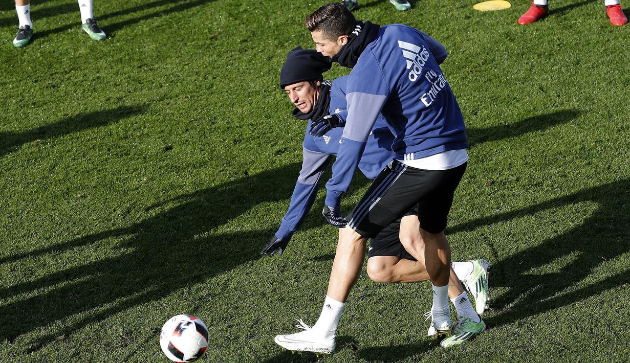 Pemain Real Madrid, Cristiano Ronaldo, berebut bola dengan Fabio Coentrao, saat latihan perdana di tahun 2017. Pada babak 16 besar Piala Raja, Madrid akan menghadapi Sevilla. (EPA/Chema Moya)