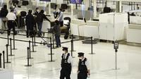 Polisi berjalan-jalan di check in counter keberangkatan di Bandara Internasional Narita, timur Tokyo, Kamis (2/12/2021). Maskapai-maskapai internasional diminta menangguhkan reservasi baru pada semua penerbangan masuk ke Jepang hingga akhir Desember terkait varian Omicron. (AP Photo/Hiro Komae)