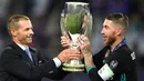 Presiden UEFA Aleksander Ceferin memberikan trofi Piala Super Eropa kepada bek Real Madrid, Sergio Ramos usai timnya menumbangkan Manchester United (MU) di Skopje, Macedonia, Selasa (8/8). Real Madrid mengalahkan MU dengan skor 2-1 (Dimitar DILKOFF / AFP)