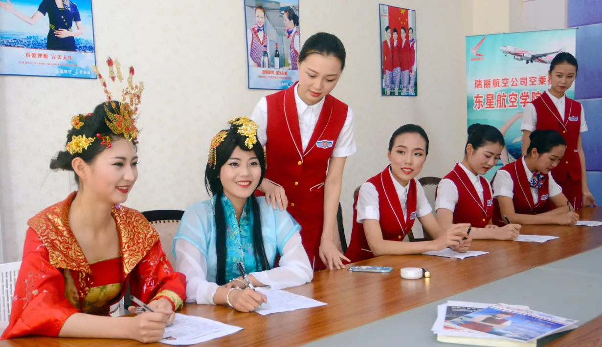 Dua orang wanita berpakaian tradisional mengikuti wawancara untuk menjadi calon pramugari di Chengdu, Provinsi Sichuan, 27 Mei 2016. Lebih dari 500 wanita cantik mengikuti sesi interview sebuah perusahaan penerbangan di Tiongkok. (REUTERS/Stringer)
