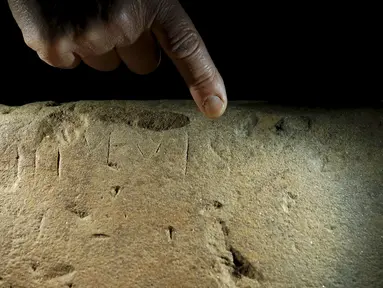 Seorang pakar sejarah menunjuk salah satu teks atau prasasti  di Florence , Italia , 20 April 2016. Teks prasasti-nya sendiri tertulis dengan bahasa yang sudah lama hilang dan ilmuwan kini sedang mendalami teks - teks tersebut. (REUTERS / Remo Casilli)