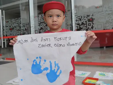 Seorang bocah memegang spanduk bertuliskan anti korupsi saat acara peringatan anti korupsi 2015 LKPP, KPK, dan ICW bertajuk Hackathon Merdeka 3.0, Di LKPP Tower kawadan Rasuna Sahid, Jakarta, Sabtu (05/12). (Liputan6.com/Faisal R Syam)