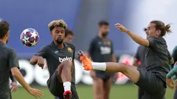 Penyerang Barcelona, Antoine Griezmann berebut bola dengan Konrad de la Fuente selama sesi latihan di stadion Da Luz, Lisbon, Portugal (13/8/2020). Barcelona akan bertanding melawan Bayern Munchen pada perempat final Liga Champions di Estadio da Luz. (Rafael Marchante/Pool via AP)