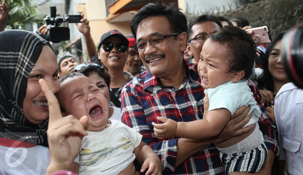 Cawagub DKI Jakarta, Djarot Saiful Hidayat saat blusukan ke Kampung Makasar, Jakarta, Kamis (8/12). Dengan disambut warga dan anak-anak Djarot menyusuri Jalan Kerja Bakti yang menjadi lokasi blusukan-nya. (Liputan6.com/Faizal Fanani)