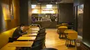 Seorang pria mengenakan masker menunggu makanannya di sebuah restoran di pusat perbelanjaan Beijing (28/1/2020). Jumlah korban meninggal dunia di Provinsi Hubei, China tengah, akibat Virus Corona bertambah 65 orang. (AP Photo/Mark Schiefelbein)