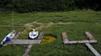 Perahu tergeletak pada dasar sungai kering di dermaga wisata di sepanjang Sungai Po, Torricella, Italia, 14 Juli 2022. Kekeringan Italia telah mengeringkan sungai-sungai penting untuk irigasi yang mengancam pertanian sekitar 3 miliar euro ($ 3,1 miliar), menurut lobi pertanian Italia Coldiretti. (AP Photo/Antonio Calanni)