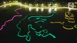 Foto udara memperlihatkan warna warni lampu Danau Archipelago di Taman Mini Indonesia Indah (TMII), Jakarta, Sabtu (31/12/2022). Pemerintah Provinsi DKI Jakarta akan memusatkan perayaan malam Tahun Baru 2023 di Taman Mini Indonesia Indah (TMII).  (Liputan6.com/Herman Zakharia)