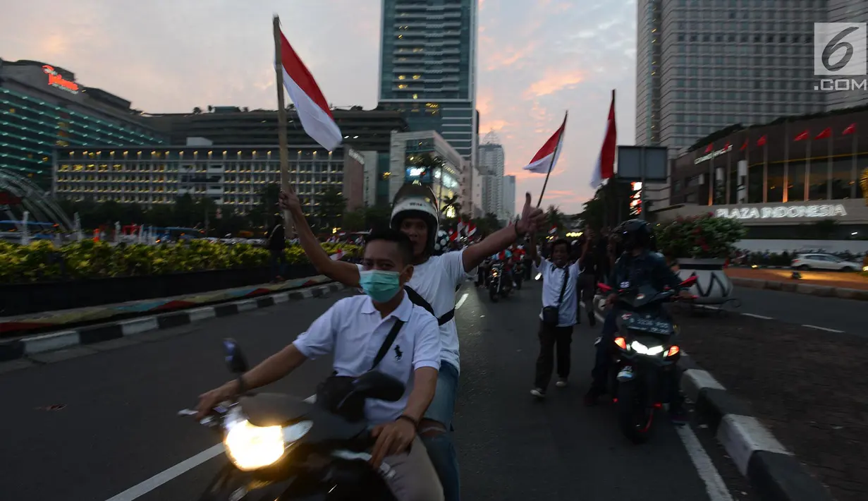 Pendukung capres-cawapres 01 Jokowi-Ma'ruf Amin berkeliling di kawasan Bundaran HI, Jakarta, Rabu (17/4). Berdasarkan hasil hitung cepat  Pasangan Jokowi-Ma'ruf Amin unggul diberbagai lembaga survei. (Merdeka.com/Imam Buhori)