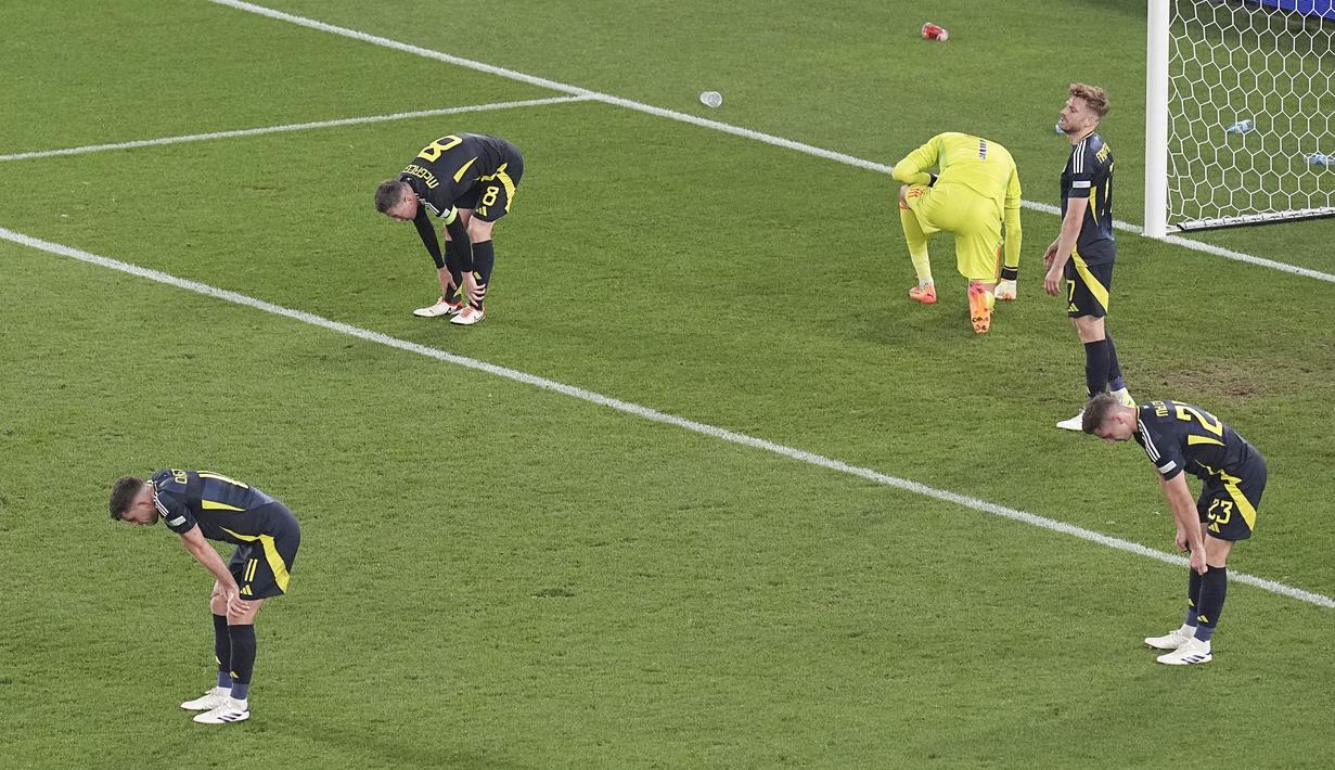 Para pemain Skotlandia tertunduk lesu setelah ditaklukkan Hungaria pada laga Grup A Euro 2024 di Stuttgart Stadium, Senin (24/6/2024). Pasukan Tartan dipaksa menyerah 0-1. (AP Photo/Ariel Schalit)