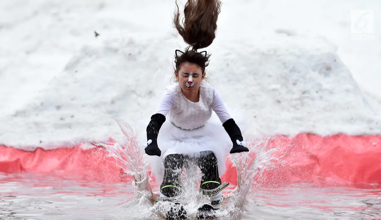 Seorang peserta dengan mengenakan kostum melompat ke dalam kolam sebagai bagian dari kompetisi komik 'Californication 9.0' di kota Logoisk, utara Minsk, Belarus, 7 April 2019. Sebanyak 8 peserta dengan kostum unik berseluncur salju untuk merayakan  akhir musim dingin. (Sergei GAPON / AFP)