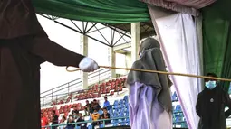 Seorang wanita dicambuk di depan umum oleh anggota polisi Syariah di Lhokseumawe, Aceh, Senin (28/6/2021). Wanita yang didakwa telah melakukan hubungan seks pranikah itu dihukum dengan 100 cambukan. (Azwar Ipank/AFP)